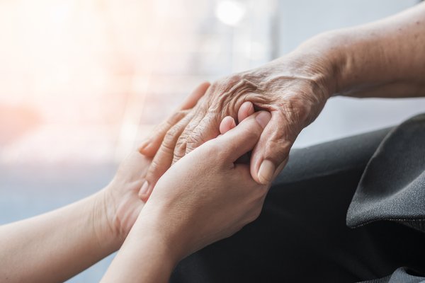memory-care-young-caregiver-holding-elderly-hands