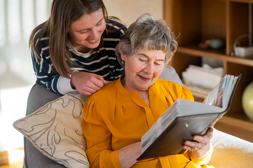 Old woman with her granddaughter look at family photos