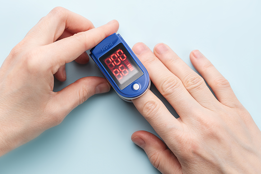 Pulse oximeter measuring oxygen saturation in blood and heart rate. Pulse oximeter on the patient's hand